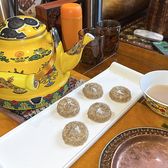 A painted teapot of butter tea with barley cakes on a tray