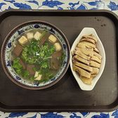 A bowl of duck-blood and vermicelli soup on a tray with a side dish