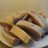 Slices of Nanjing salted duck, pale and lean, on a white plate