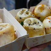 Shengjian buns in takeaway boxes, browned bases and sesame on top
