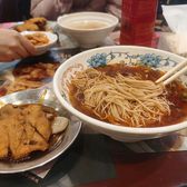 A bowl of fine Suzhou noodles in clear broth with side dishes