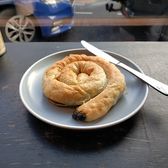 A coiled popiah roll on a plate with a fork