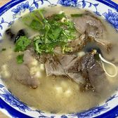 A bowl of yangrou paomo, lamb and torn bread under coriander
