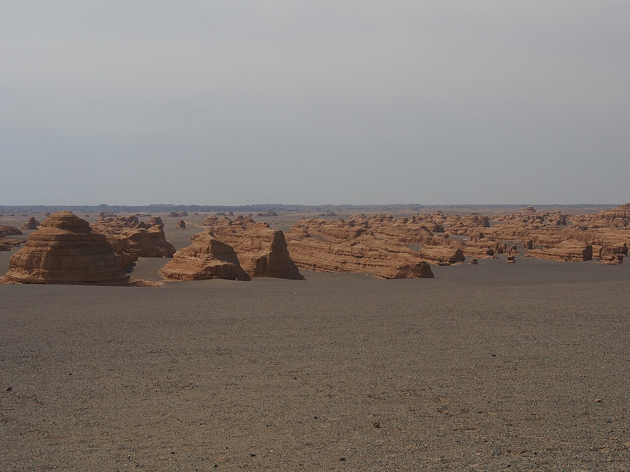 Wind-carved rock ridges standing out of the desert in the Dunhuang yardang park