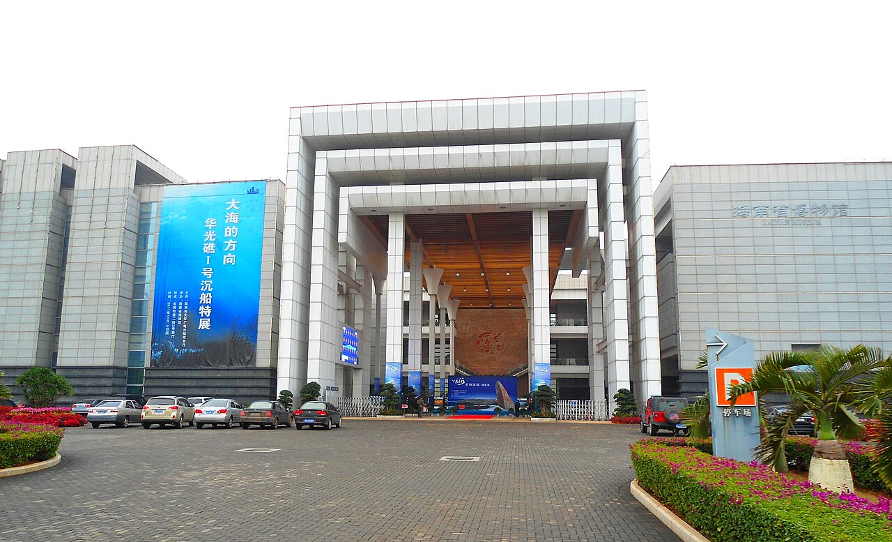 The entrance facade of Hainan Provincial Museum, its name in gold above the glass doors.