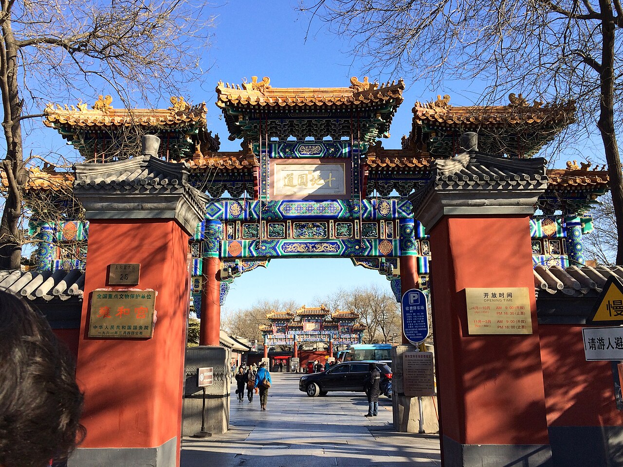 The painted gateway at the entrance to the Lama Temple, visitors walking through beneath it