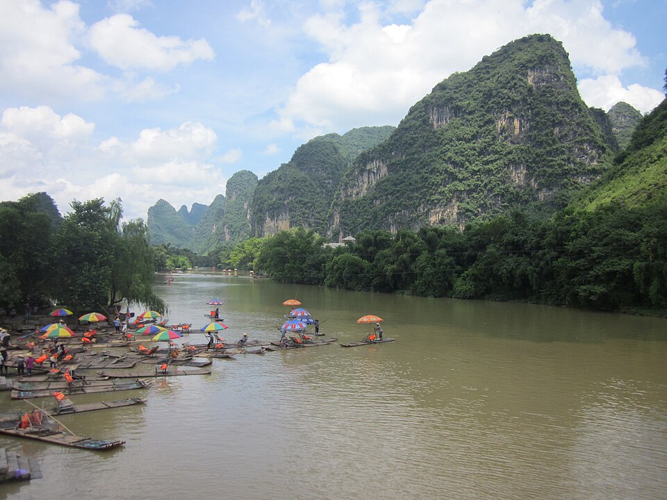 A bamboo raft drifting the Li River between karst peaks near Yangshuo