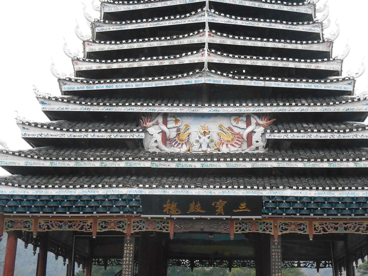 A traditional Dong minority drum tower in Rongjiang county, Guizhou, its tiered wooden roofs rising above the village.