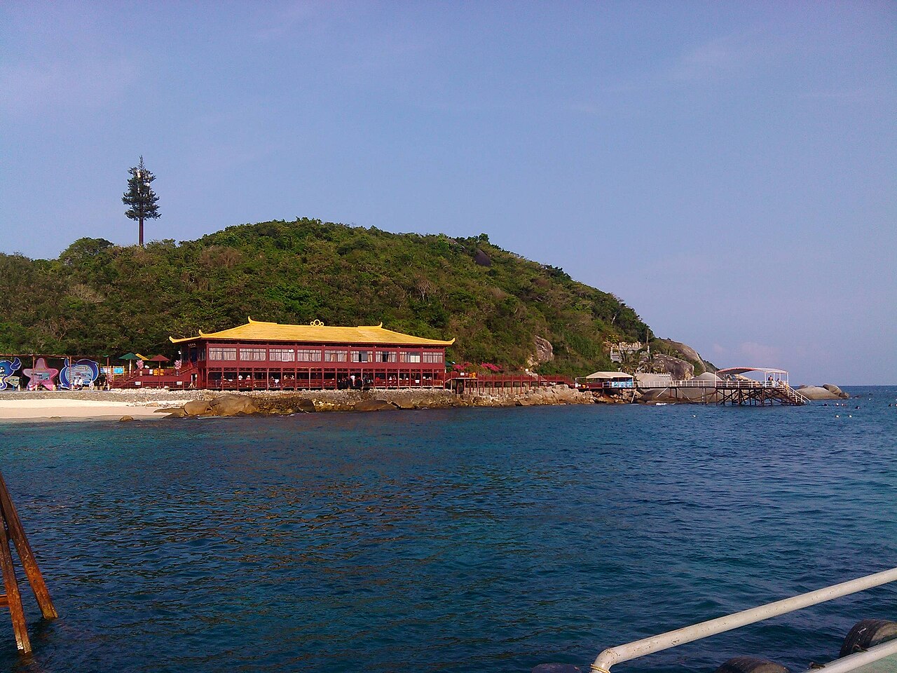 Aerial view of Wuzhizhou Island's clear water and coral reefs off Haitang Bay