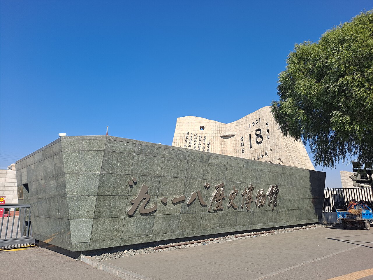 The entrance of the '9.18' Museum in Shenyang, with the museum name in gilt characters and a stone calendar monument showing 1931 and 18 September behind it.