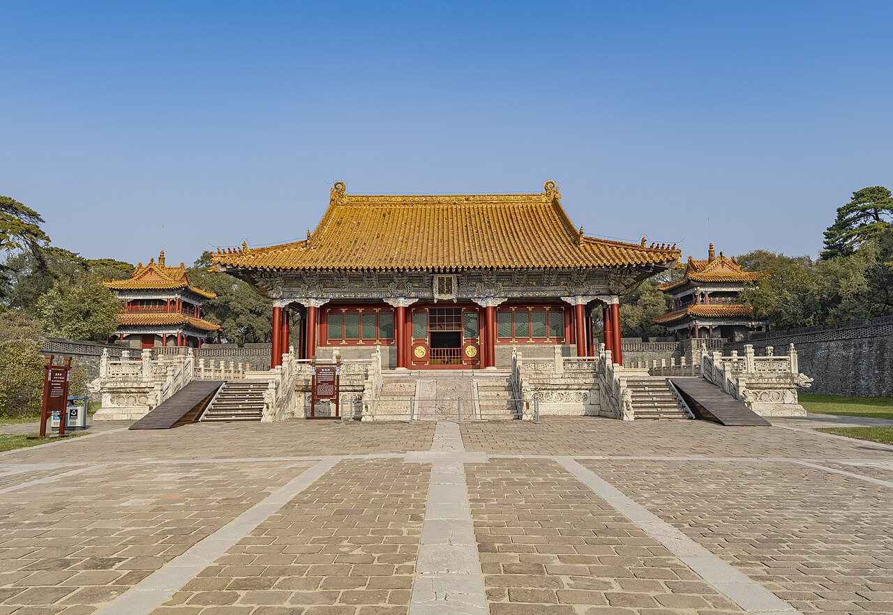 The Long'en Hall at Fuling Tomb, with a golden-yellow tile roof and red columns, approached by a stone-paved courtyard.