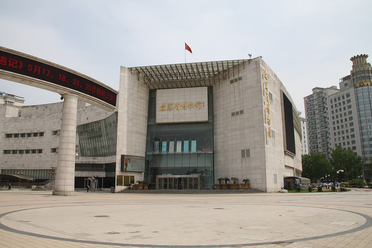 The modern grey-stone facade of Liaoning Provincial Museum above a broad entrance plaza.