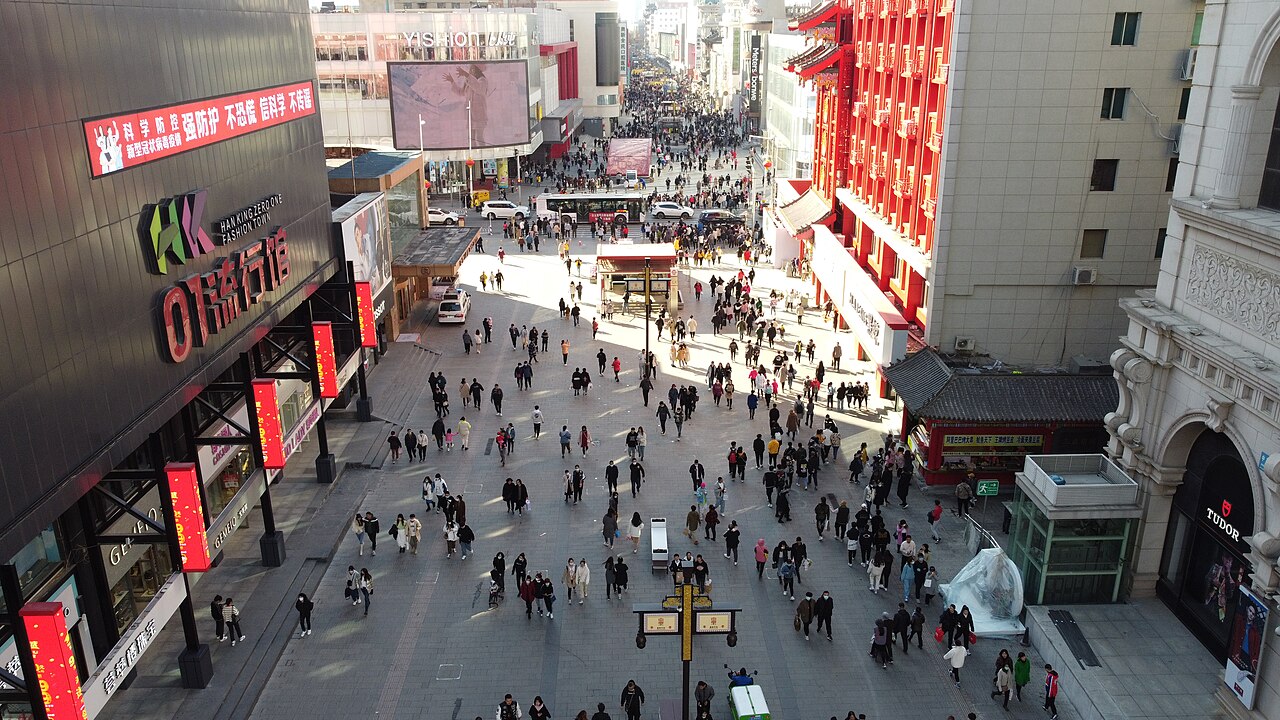 Crowds drifting between shopfronts and snack stalls on Zhongjie, Shenyang's old commercial walking street.
