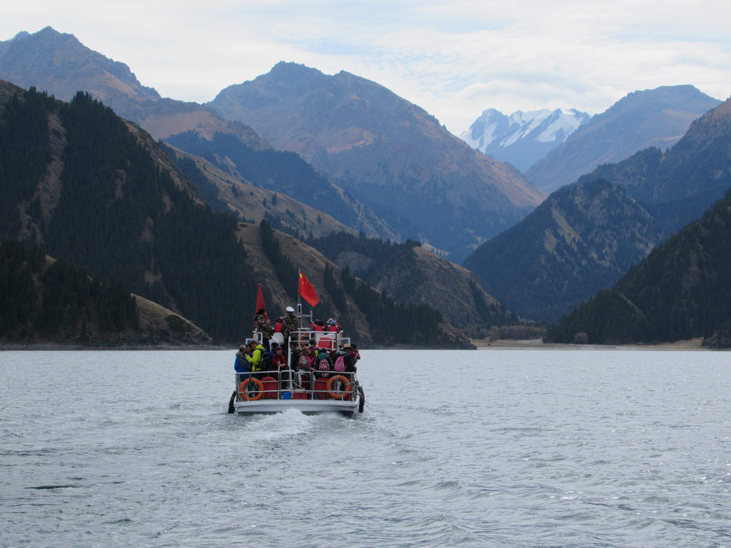 A tour boat crossing Heavenly Lake under the Tianshan peaks