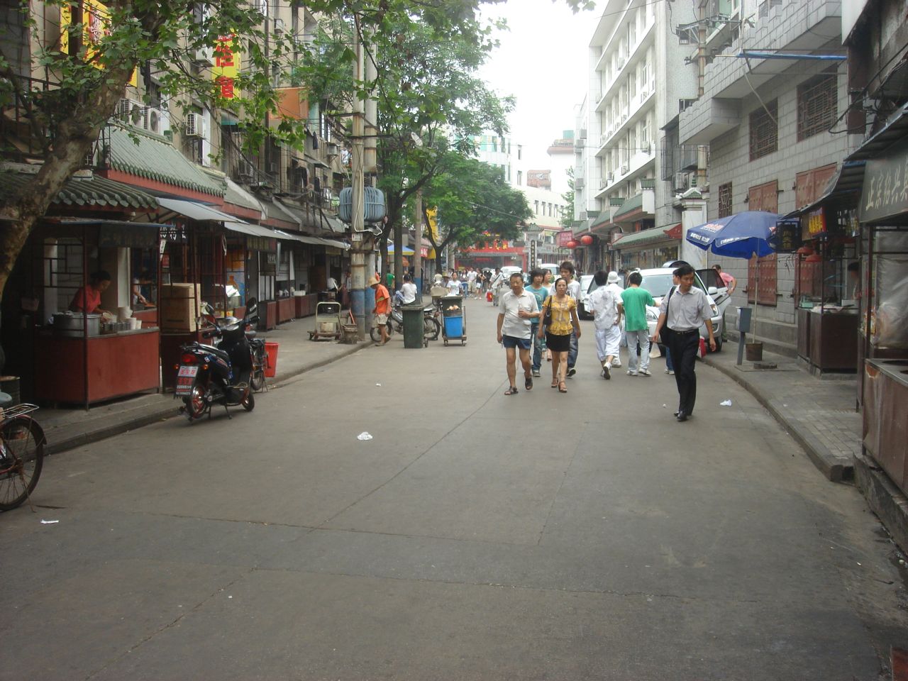 A crowded food-stall lane in Hubu Alley, Wuchang, strung with red lanterns and steaming snack pots
