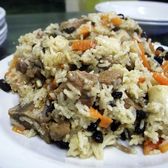 A plate of lamb pilaf, the rice cooked through with carrot and raisins