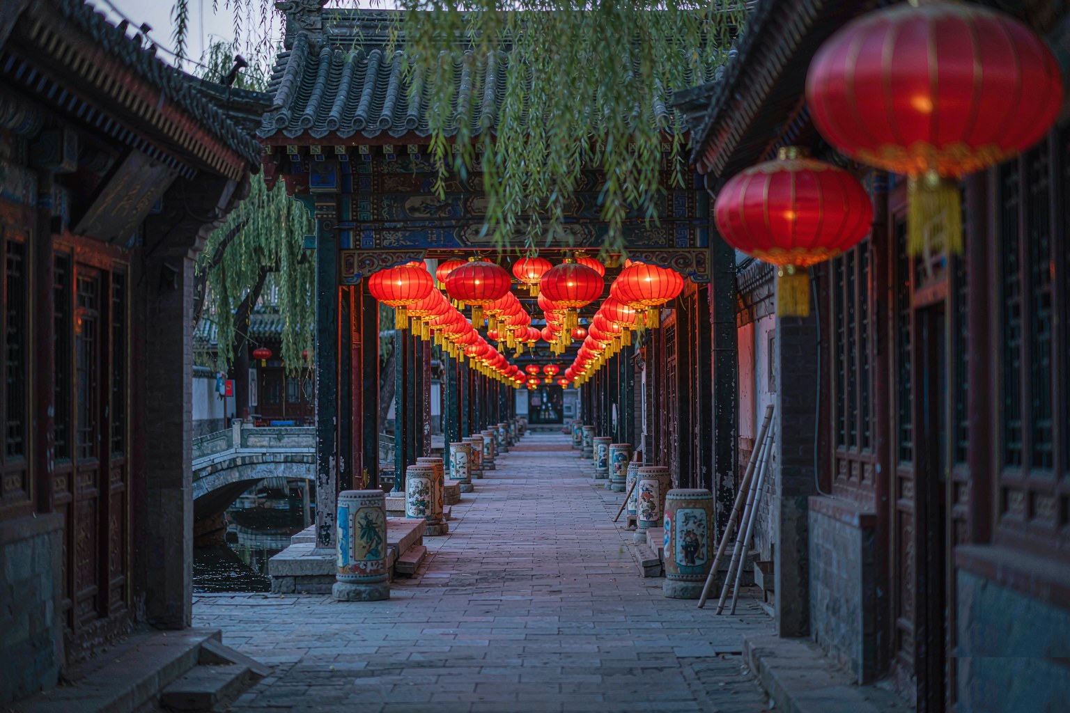 Red lanterns strung above a quiet hutong alley in old Beijing