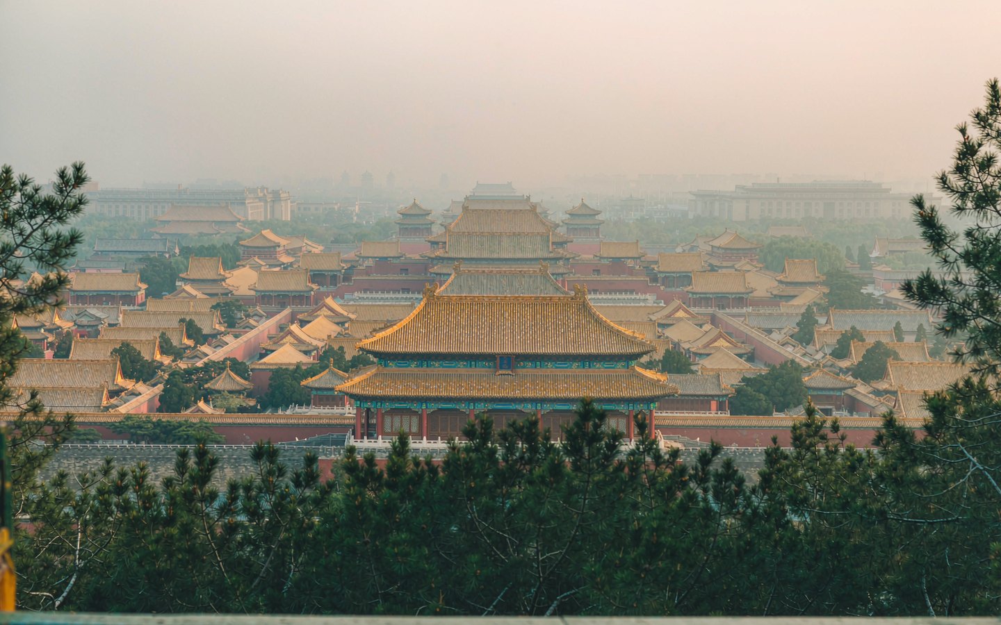 Golden Forbidden City rooftops seen from a hilltop pavilion
