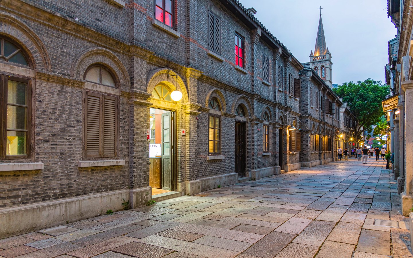 Granite-slab lane with brick mansions and small cafe lights