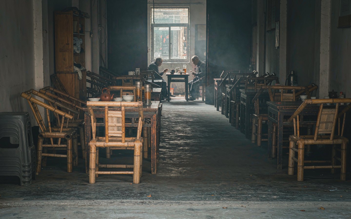 Old teahouse interior with kettles, benches and worn wooden tables