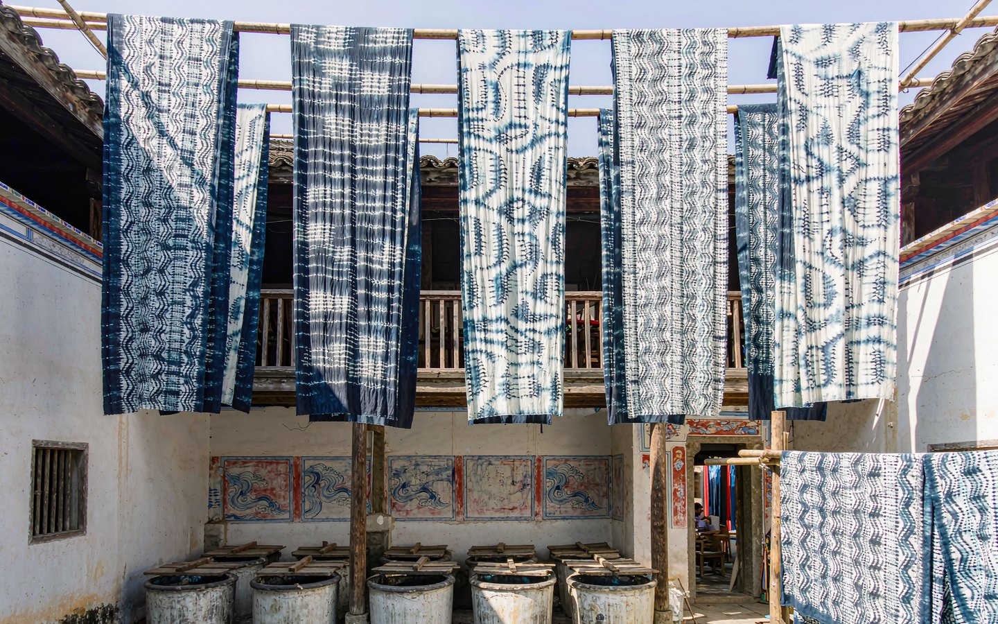 Indigo-dyed cloth with white patterns drying in a Bai courtyard