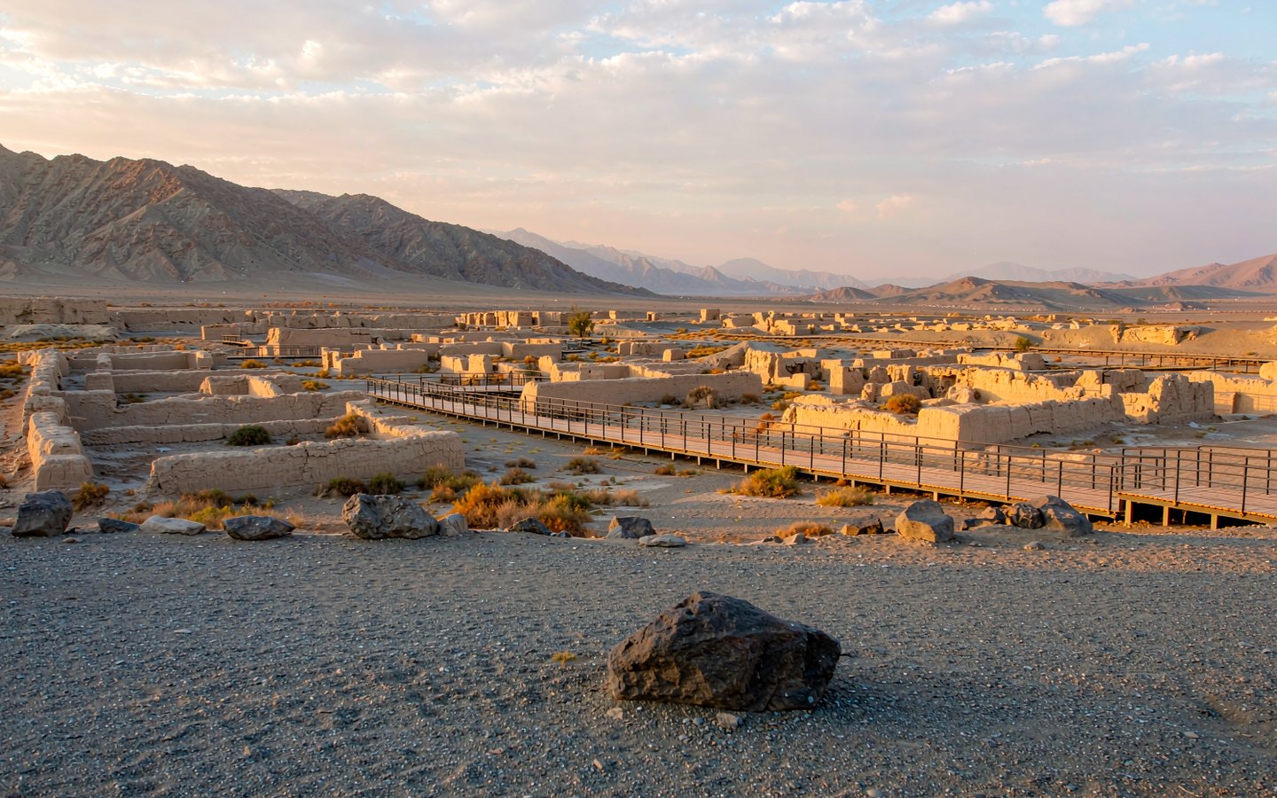 Excavated Han relay-station ruins in the desert beside low boardwalks