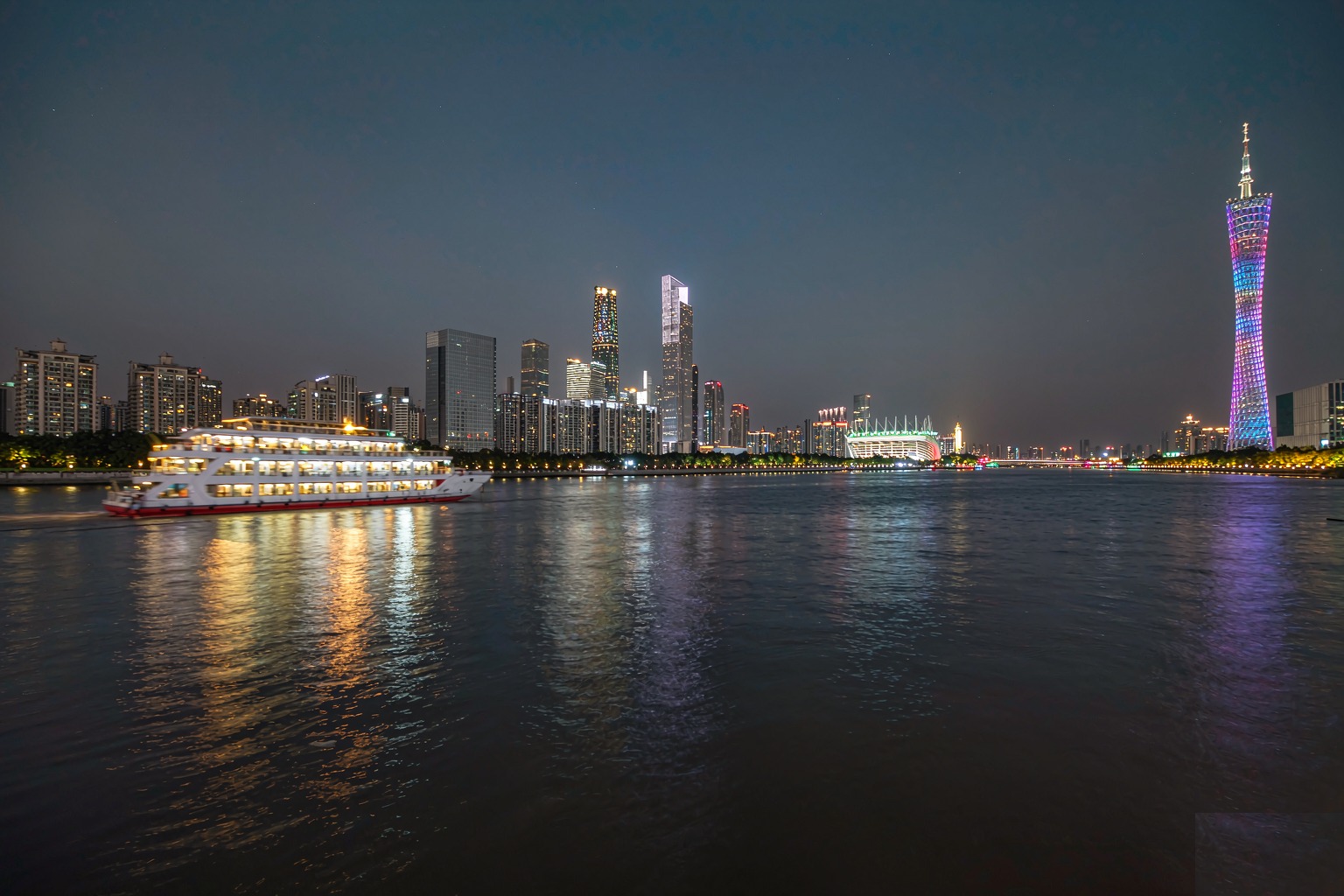 A night cruise boat on the Pearl River with the lit-up Canton Tower and skyline behind, Guangzhou