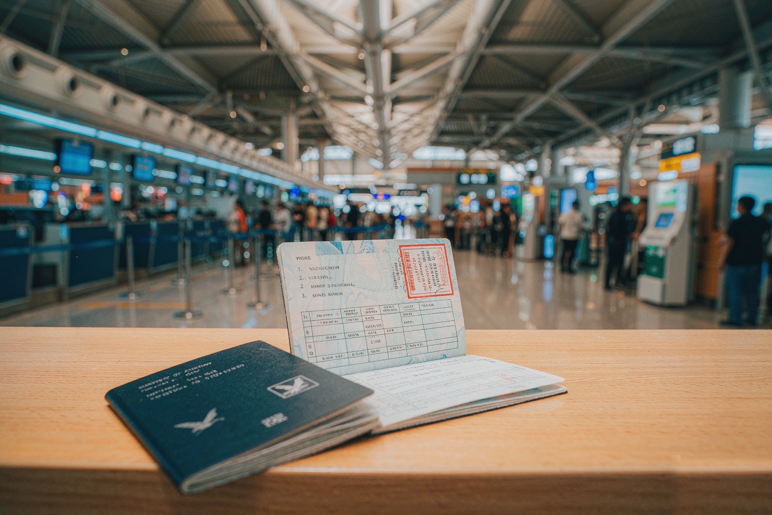 A passport with a Chinese entry stamp at an airport immigration hall