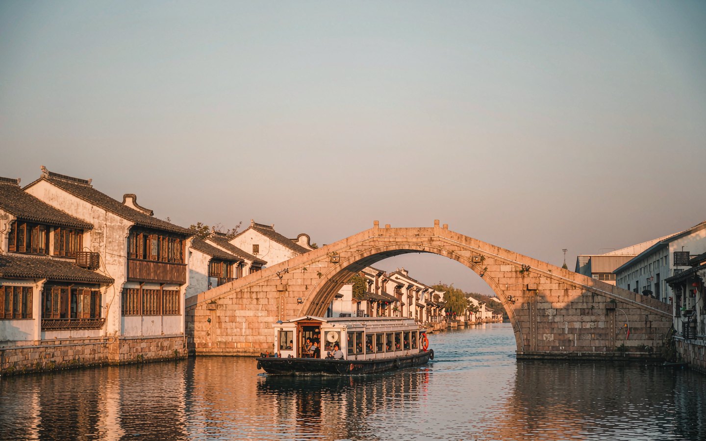 Stone arch bridge over the Grand Canal with an old-style water bus