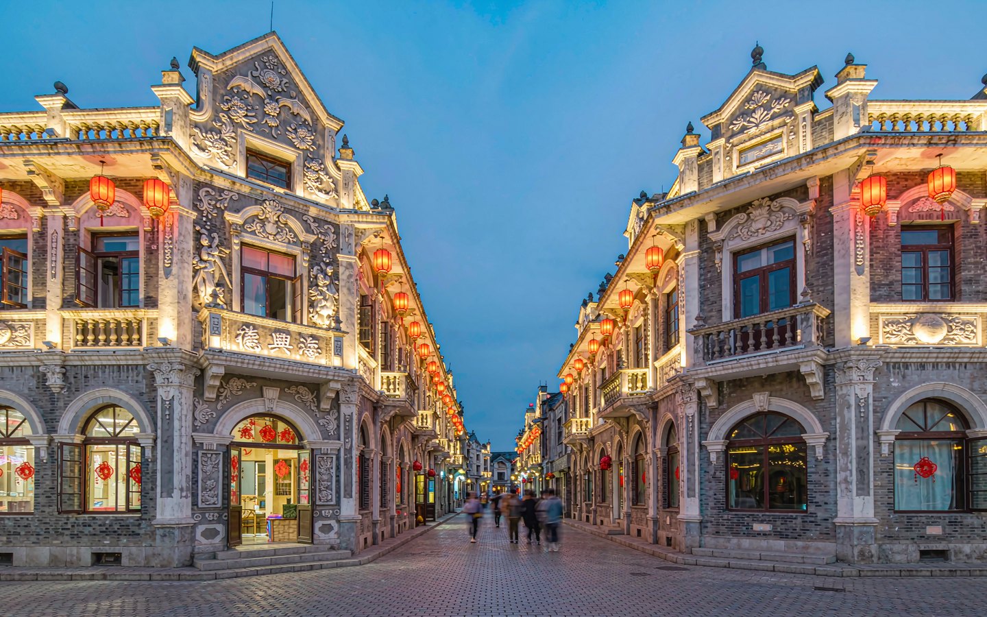 Ornate baroque facade with Chinese motifs above a lantern-lit street
