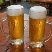 Two tall glasses of cold golden lager on an outdoor table
