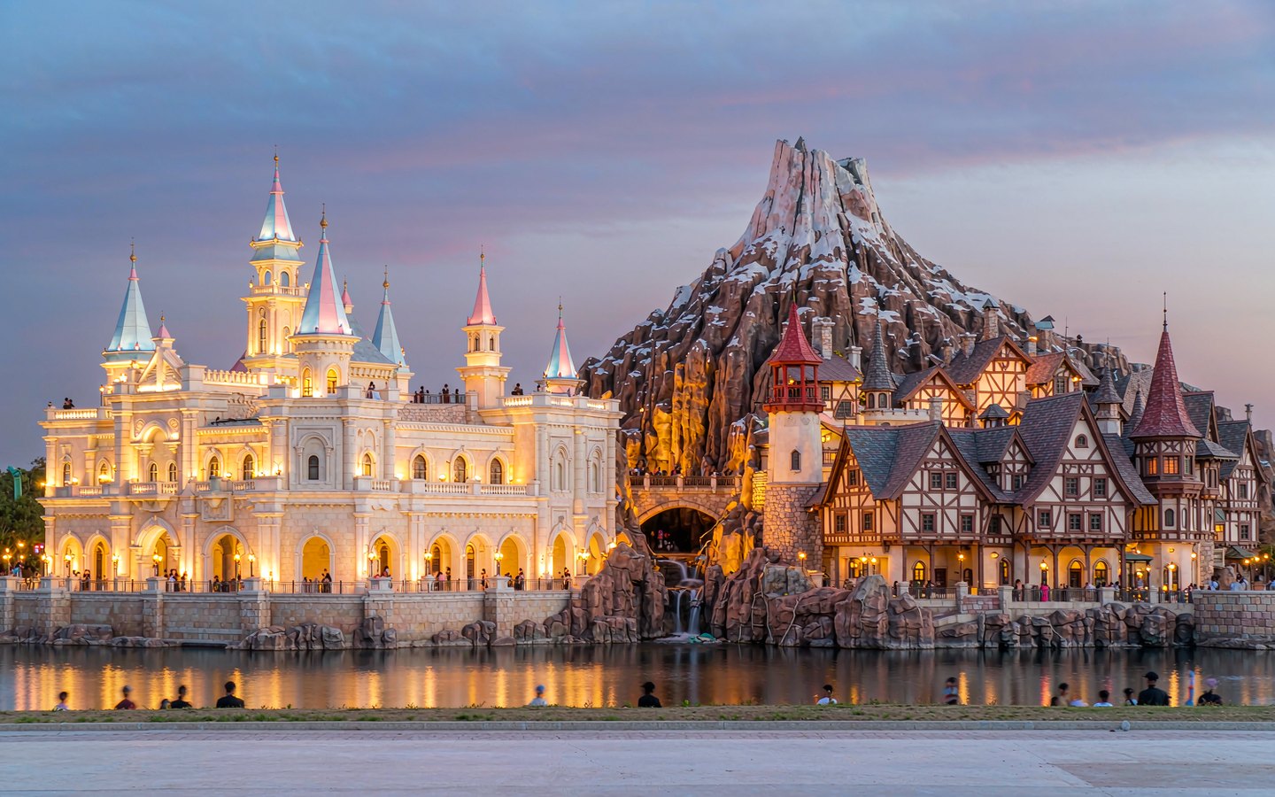 Fairy-tale castle and a snow-capped mountain land at dusk