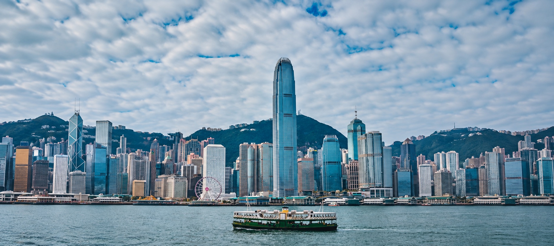 A Star Ferry crossing Victoria Harbour with the skyline behind
