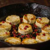 Thick slices of white goat milk cheese pan-fried until golden in a cast iron skillet, scattered with dried chilli and spring onion