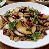 Sliced wild mushrooms stir-fried with dried chilli and garlic on a plate