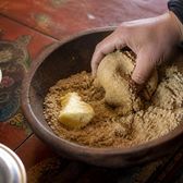 A bowl of roasted barley flour with butter, worked into a dough by hand