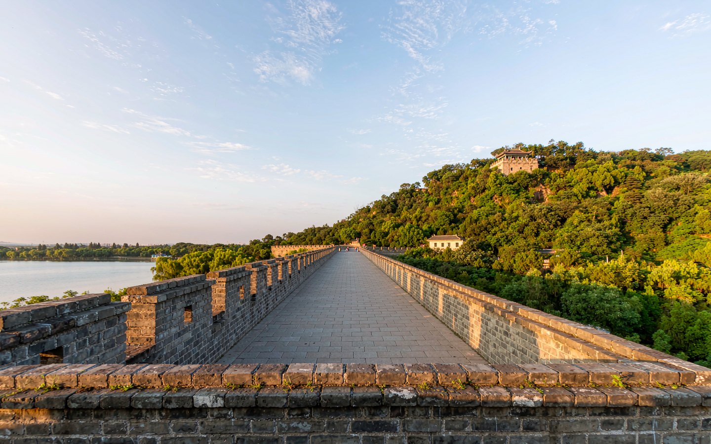 Walkway atop a Ming city wall between a lake and forested hills