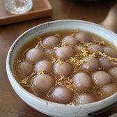Small taro balls in thick amber syrup scattered with osmanthus flowers