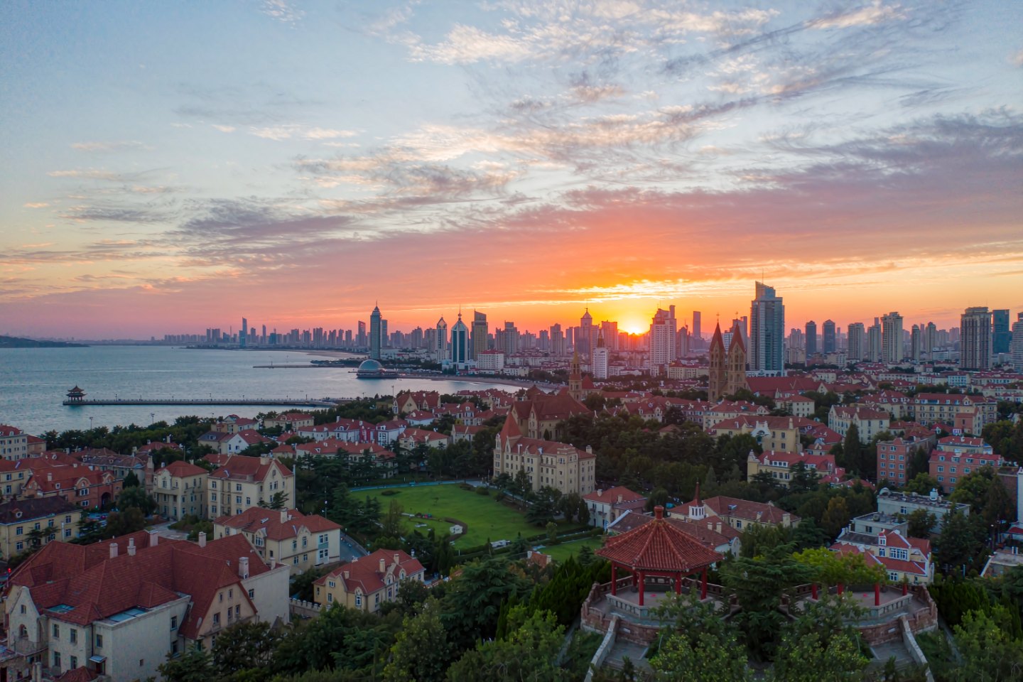 Sunset over Qingdao's old town roofs and bay from Signal Hill