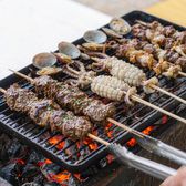 Lamb, squid and clam skewers grilling over coals at a Qingdao street barbecue