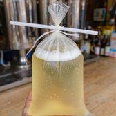 A plastic bag of fresh unfiltered draft beer tied at the top with a straw in it