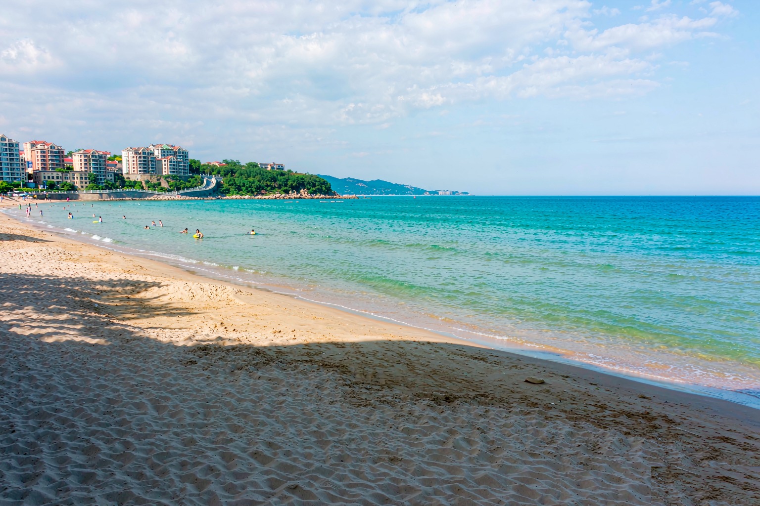 Bathers on the golden sand of No.1 Bathing Beach on a Qingdao summer afternoon