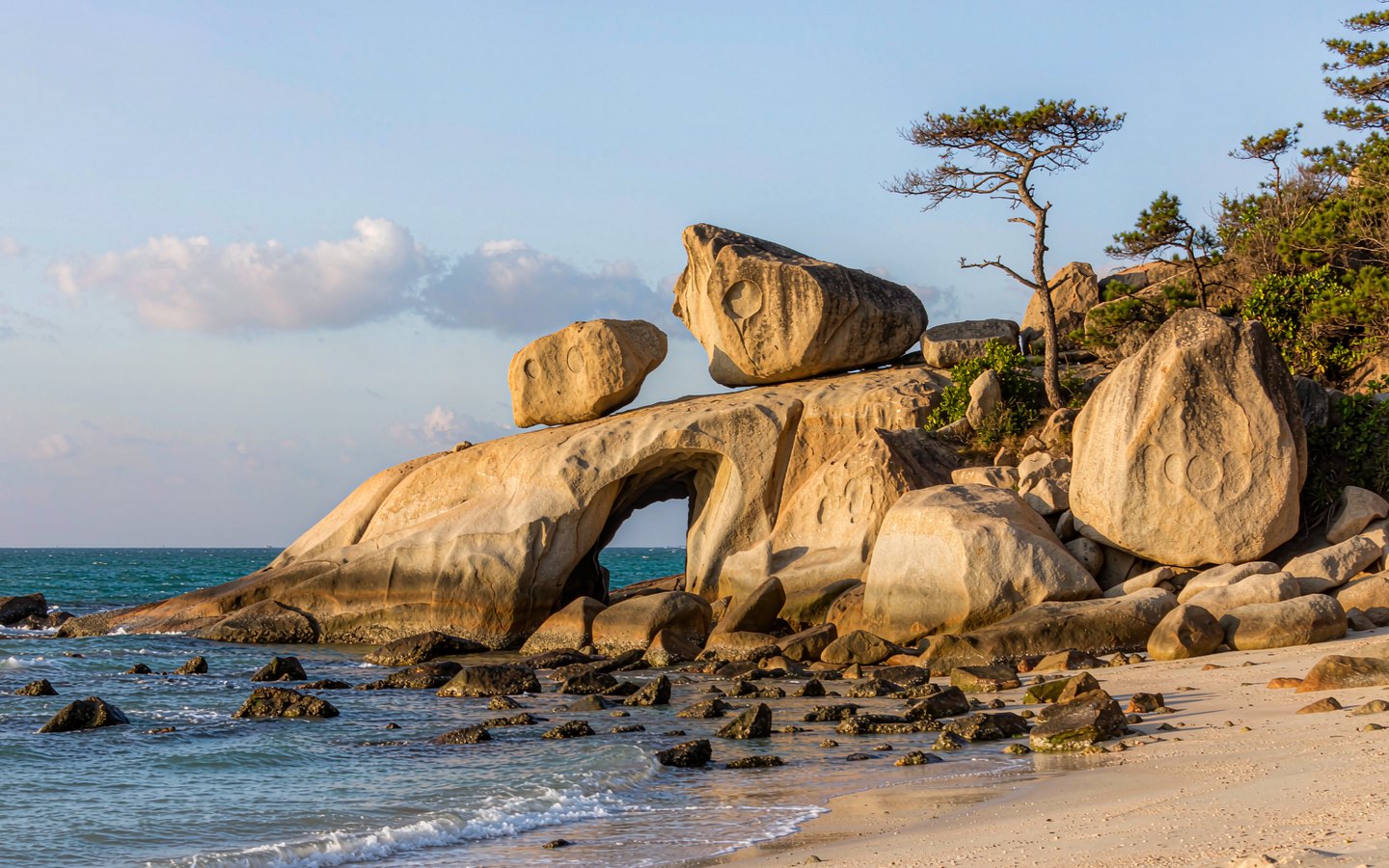 Granite sea cliffs and carved rocks above a rocky bay on the Sanya coast