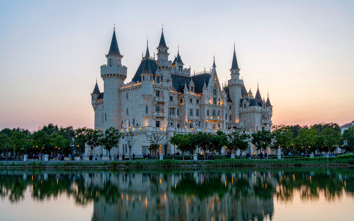 Fairy-tale castle across a lagoon with evening lights coming on