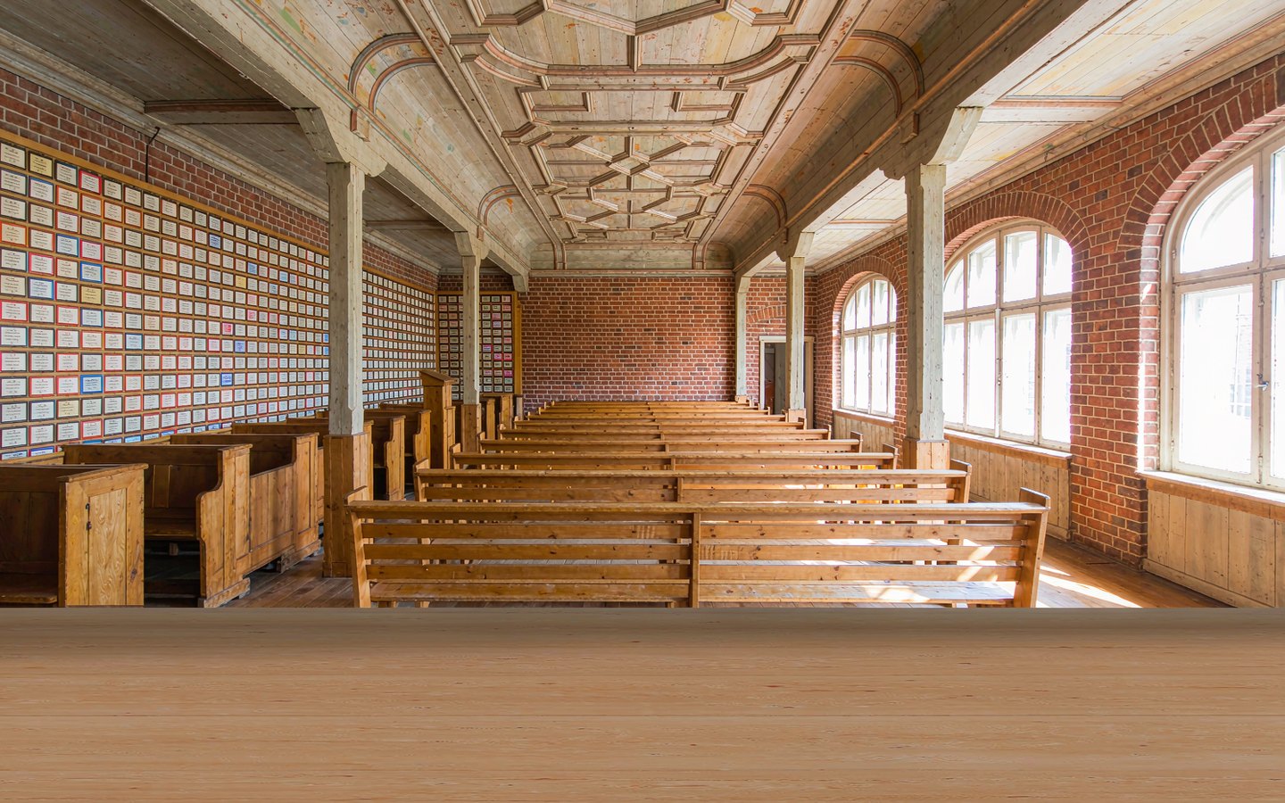 Restored brick synagogue interior with wooden benches and quiet light