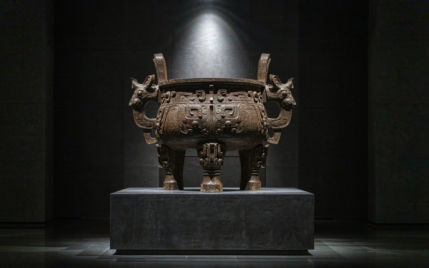 Ancient bronze ritual vessels in a softly lit museum gallery