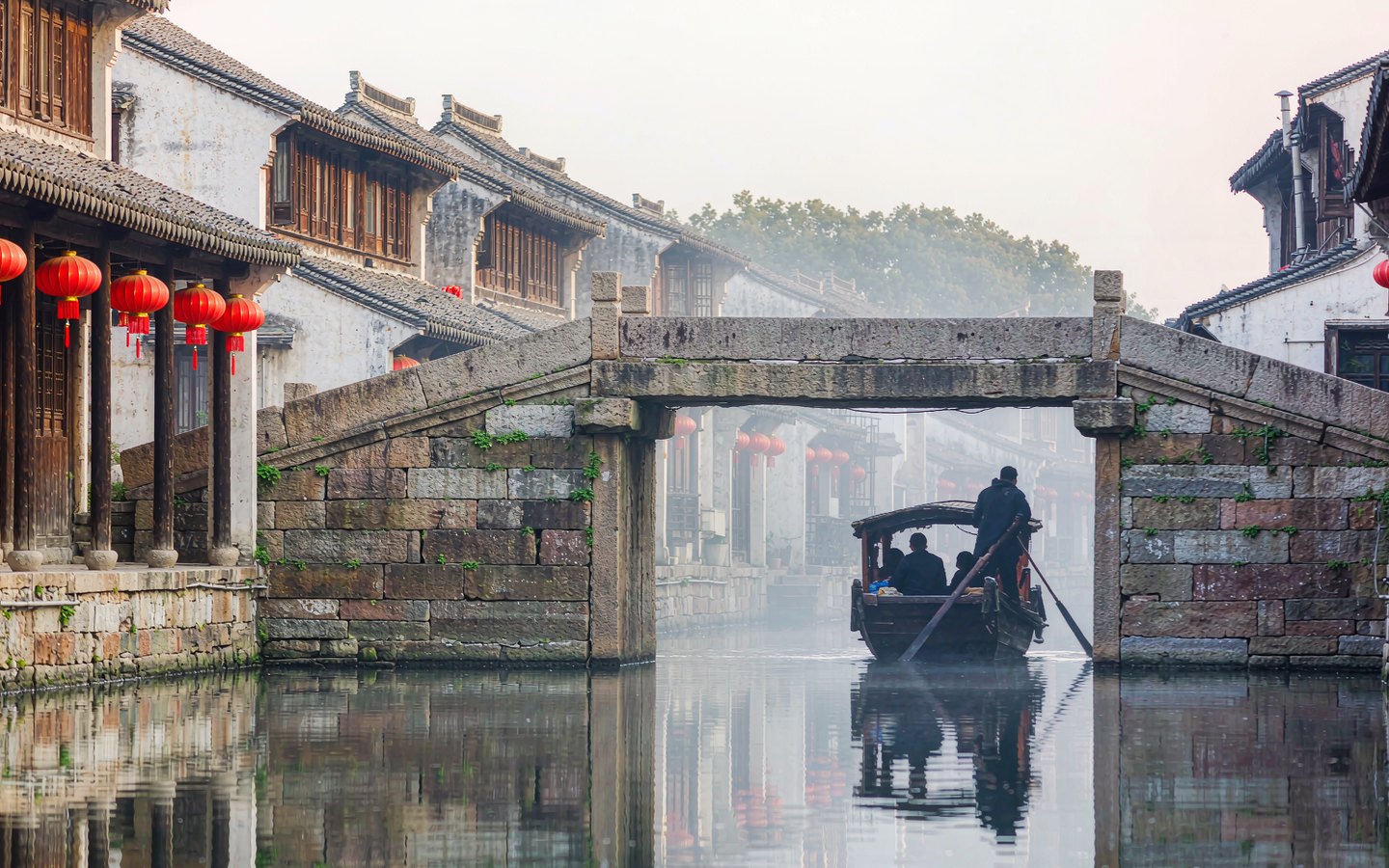 Stone arch bridge over a canal lined with old wooden houses