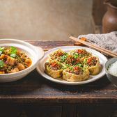 Braised pork belly with preserved mustard greens and Hakka stuffed tofu on a rustic round table