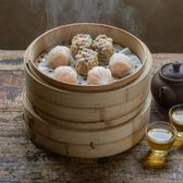 Bamboo steamers with har gow and siu mai beside a pot of pu-erh tea at Cantonese morning tea