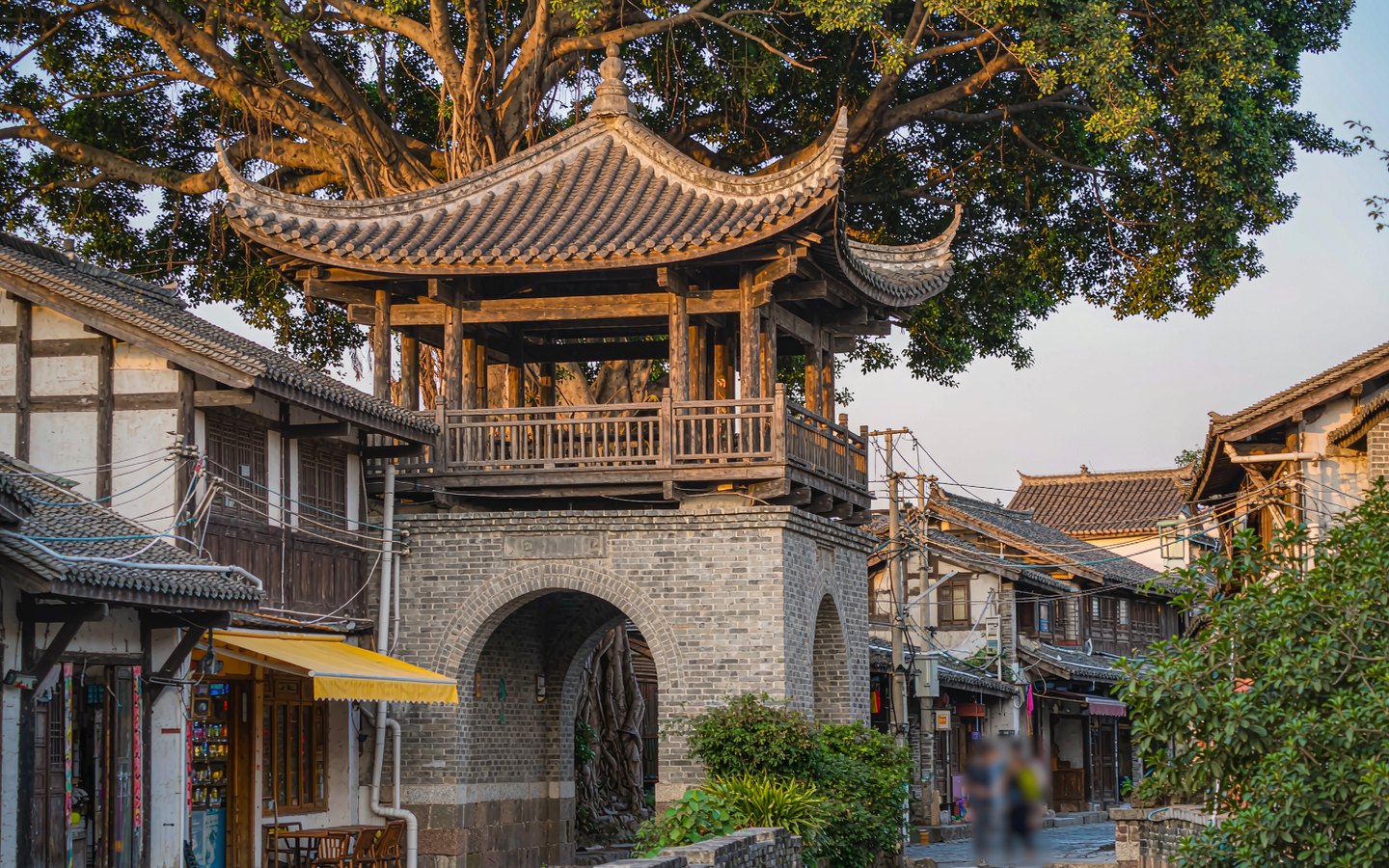 Restored Lingnan gate tower above narrow creative-district lanes